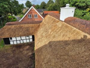 Nyt stråtag set fra oven, som viser tagfladen, den hvide skorsten og bindingsværk.